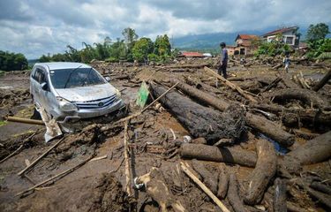 Warga melihat sebuah mobil yang terdampak banjir bandang di Nagari Bukik Batabuah, Agam, Sumatera Barat, Minggu (12/5/2024)