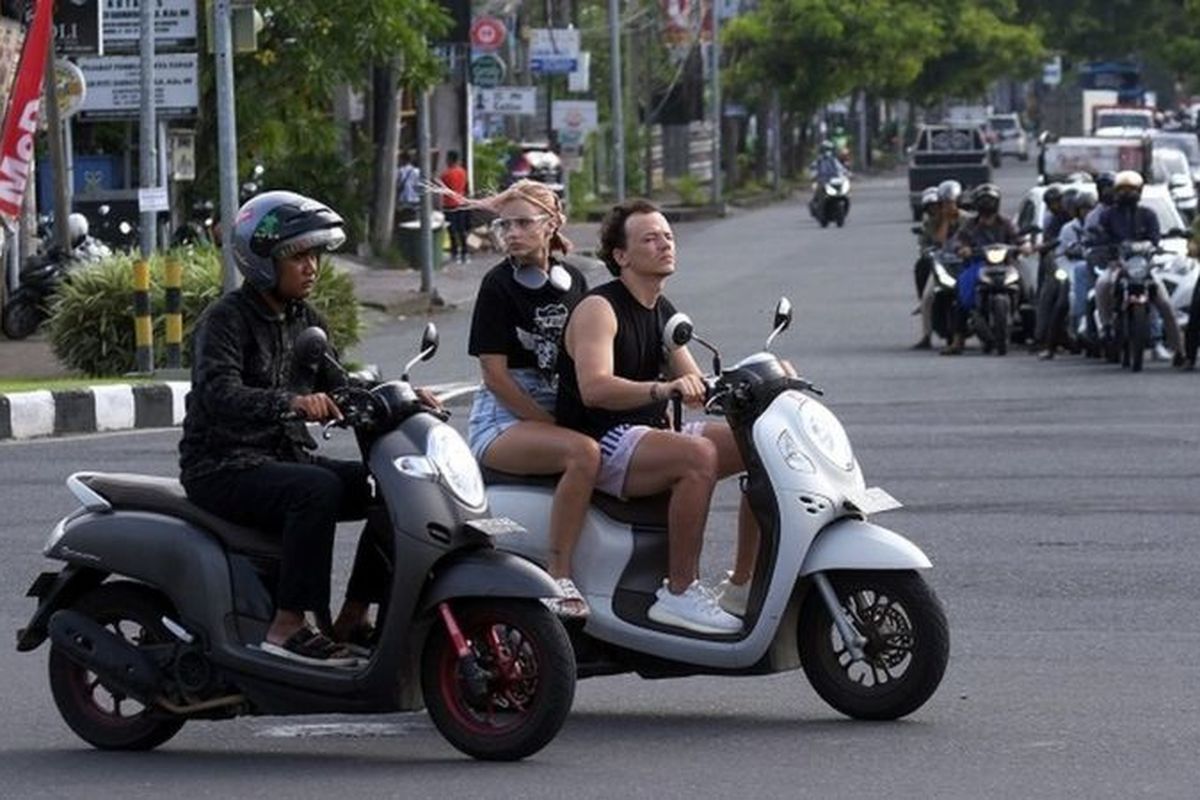 Sejumlah turis asing mengendarai sepeda motor tanpa mengenakan helm di Jalan Sunset Road, Kuta, Badung, Bali, Selasa (28/2/2023).