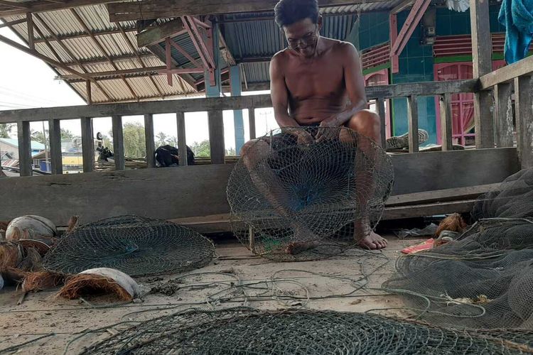 Gumurh, mantan nelayan udang yang kini menjadi pembubu kepiting bakau terlihat merapikan jaring bubunya, Jumat (30/10/2020).