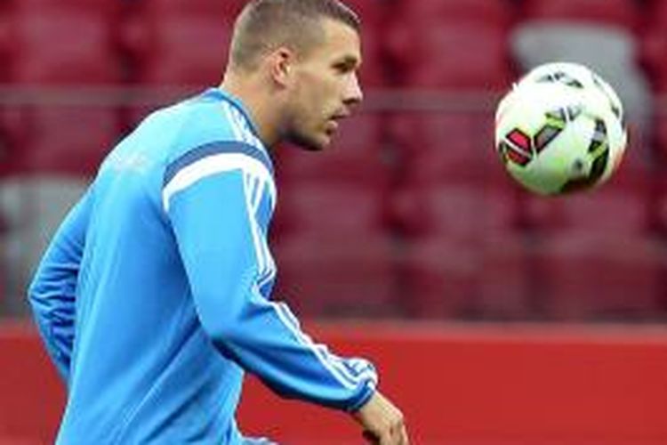 Penyerang Arsenal, Lukas Podolski, mengikuti sesi latihan tim nasional Jerman, di National Stadium, Warsawa, 10 Oktober 2014.