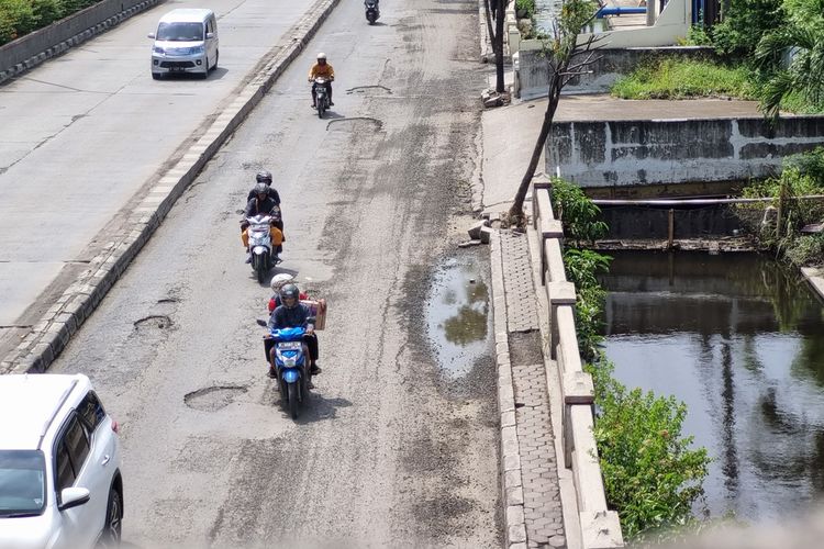 Jalan rusak di ruas jalan nasional yang berlokasi di Jalan Kaligawe Raya Semarang paska terkena banjir, Kamis (5/1/2023).