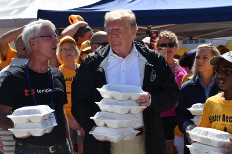 Presiden Amerika Serikat Donald Trump membagikan makanan kepada korban Badai Florence pada Kamis (19/9/2018) di New Bern, Carolina Utara. (AFP/Nicholas Kamm)