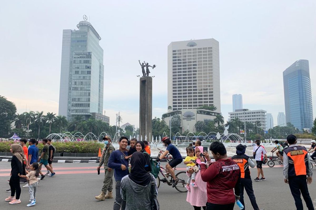 Warga tampak antusias berfoto-foto dengan latar belakang Monumen Selamat Datang yang berada ditengah-tengah Bundaran HI, saat mengikuti HBKB di Jalan MH Thamrin, Jakarta Pusat, Minggu (22/5/2022).
