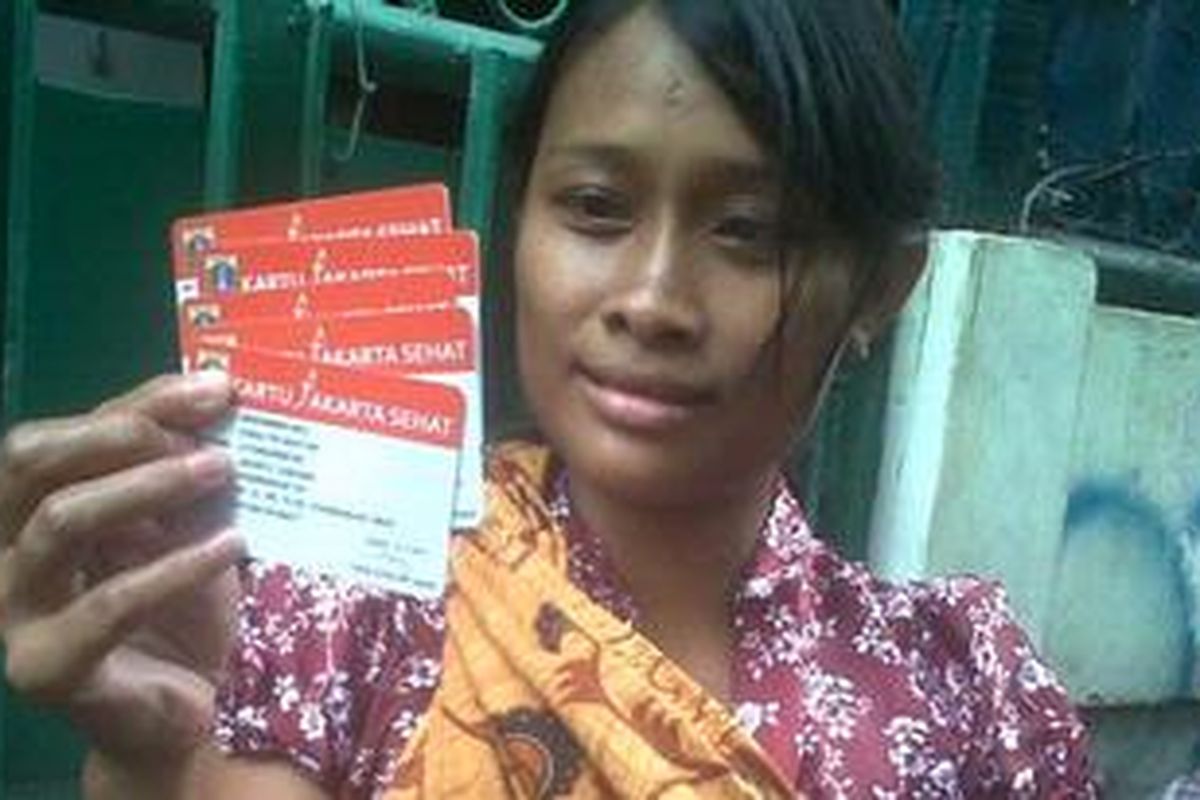 Dewi Haryati (27) warga Kelurahan Pademangan Timur, Jakarta Utara, menerima kartu sehat, Sabtu (10/11/2012). Ia berharap kartu sehat dapat menjamin warga miskin mendapatkan layanan kesehatan yang baik. 