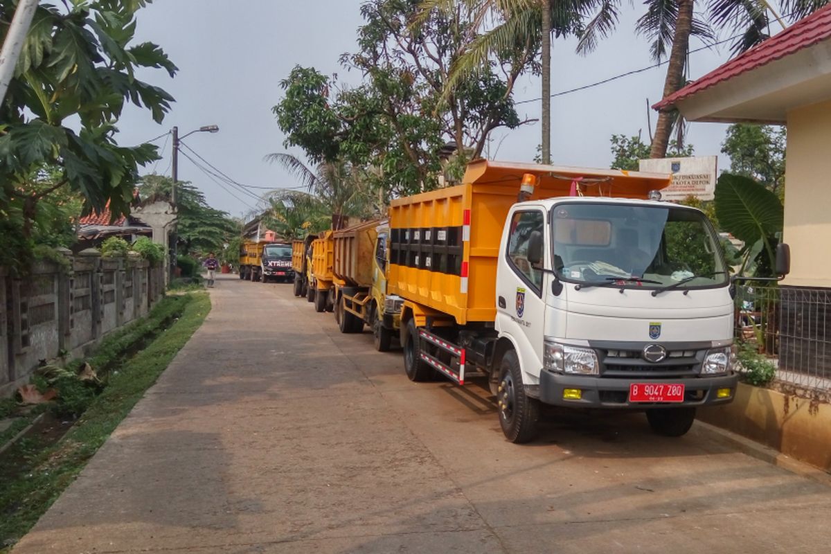 Truk-truk sampah yang terparkir di jalan menuju Tempat Pengolahan Akhir (TPA) Cipayung, Depok, Senin (14/8/2017). Truk-truk ini sengaja tak dioperasikan oleh para sopir dan kernet yang mogok kerja untuk menuntut dibayarkannya uang lembur.