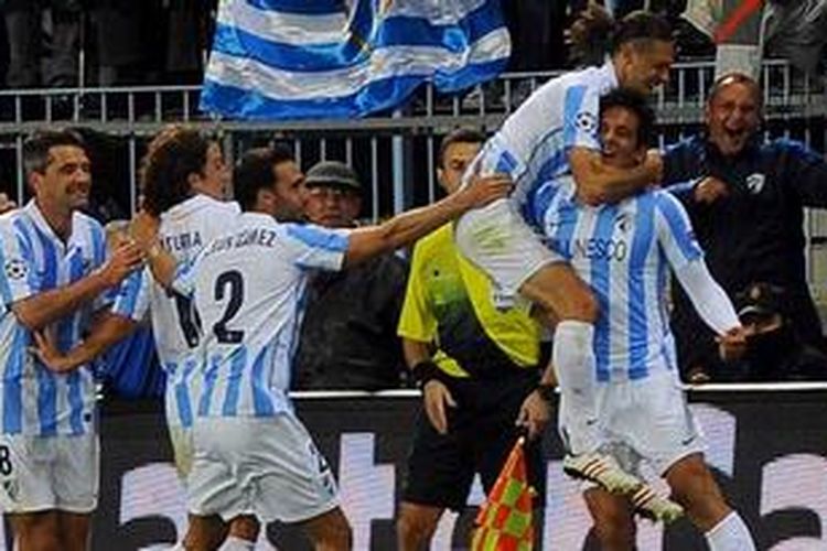 Striker Malaga, Roque Santa Cruz (kanan) disambut rekan-rekannya setelah mencetak gol ke gawang FC Porto pada leg kedua babak 16 besar Liga Champions, Rabu atau Kamis (14/3/2013) dini hari WIB. Itu menjadi gol penentu kemenangan Malaga 2-0, sekaligus lolos ke perempat final karena unggul agregat 2-1.