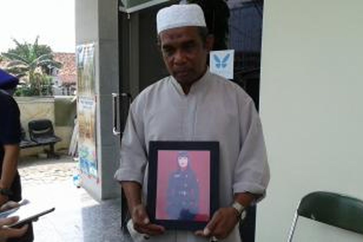 Deddy Darwis Wailissa, memegang foto anaknya yang telah meninggal dunia, Gayatri Wailissa, di RSPAS Gatot Subroto, Jumat (24/10/2014).
