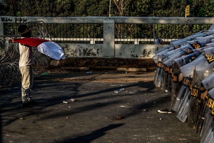 Seorang pelajar berdiri di depan polisi saat berunjuk rasa di Senayan, Jakarta, Senin (30/9/2019). Para pelajar menolak Rancangan Kitab Undang-Undang Hukum Pidana (RKUHP) dan Undang-Undang Komisi Pemberantasan Korupsi (UU KPK).