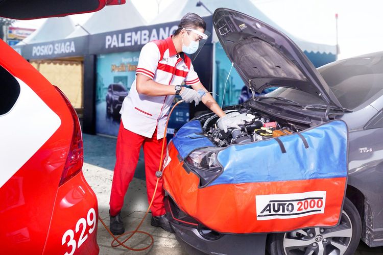 Ilustrasi Mekanik Auto2000 sedang memperbaiki mobil Toyota AutoFamily di Posko Siaga Auto2000.
