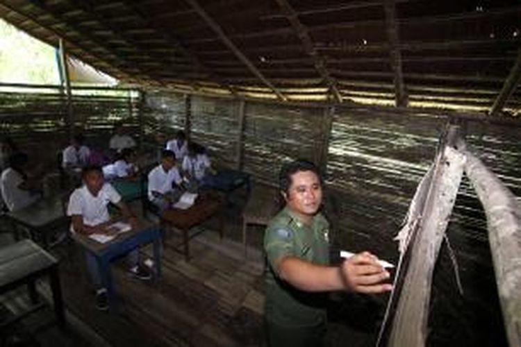 Noldy Lumangkibe, guru dipulau terluar di Sulawesi Utara sedang memberikan pelajaran bagi siswanya yang belajar di bangunan sekolah sangat sederhana di Desa Bannada.