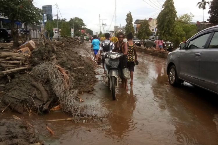 Warga mendorong motor melintasi sisa lumpur akibat banjir bandang di Sentani, Kabupaten Jayapura, Papua, Minggu (17/3/2019). Berdasarkan data BNPB, banjir bandang yang terjadi pada Sabtu (16/3) tersebut mengakibatkan 42 orang tewas. ANTARA FOTO/Gusti Tanati/wpa/ama.