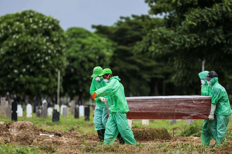 Petugas pemakaman membawa peti jenazah pasien suspect virus corona atau Covid-19 di TPU Tegal Alur, Jakarta Barat, Kamis (26/3/2020). Pemprov DKI Jakarta telah menyiapkan dua tempat pemakaman umum (TPU) untuk memakamkan pasien terjangkit virus corona (Covid-19) yang meninggal dunia, yakni di TPU Tegal Alur di Jakarta Barat dan TPU Pondok Ranggon di Jakarta Timur. Jenazah yang dapat dimakamkan di sana, yakni yang berstatus pasien dalam pengawasan (PDP) dan berstatus positif terjangkit virus corona.