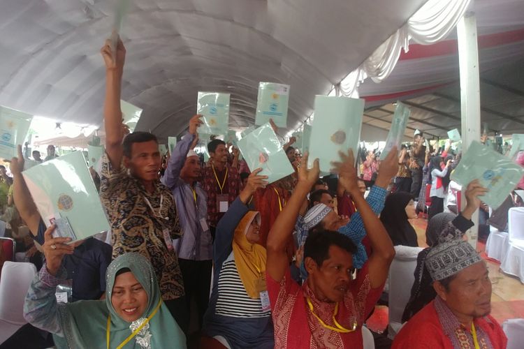 Warga Banten memamerkan serifikat tanah dalam acara penyerahan sertifikat yang dihadiri Presiden Jokowi di Desa Muruy, Pandeglang, Banten, Rabu (4/10/2017). 
