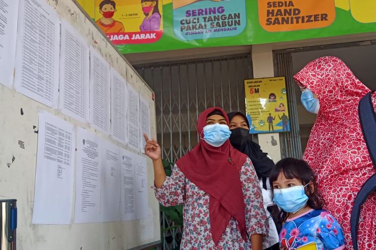 Para orangtua melihat pengumuman hasil Penerimaan Peserta Didik Baru (PPDB) 2021 di SMAN 1 Depok, Sleman, DIY, Jumat (2/7/2021).