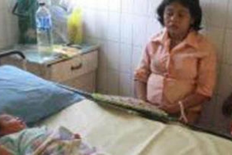 Ariyanti dan bayinya terpaksa harus bertahan di RS Dr Soegiri Lamongan, karena belum melunasi biaya persalinan, Minggu (26/1/2014). 