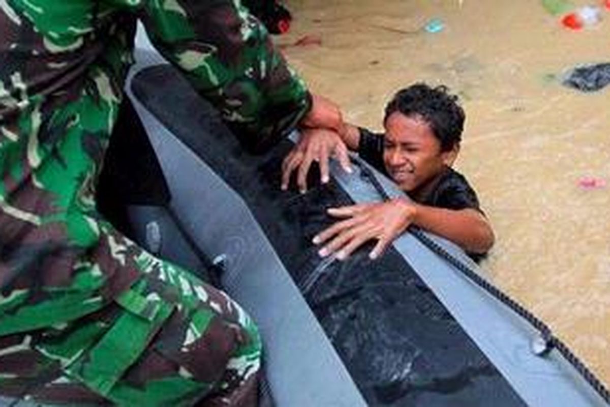 Anggota TNI mengevakuasi warga saat banjir melanda Kelurahan Aur, Kecamatan Medan Maimun, Medan, Kamis (6/1/2011). Banjir melanda sebagian kota Medan setelah hujan deras yang turun malam sebelumnya. 