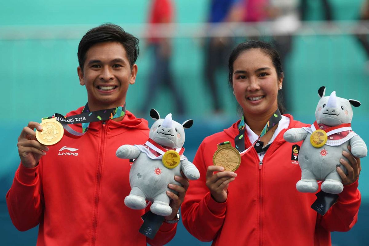 Petenis ganda campuran Indonesia Christopher Rungkat (kiri) dan Aldila Sutjiadi  memperlihatkan medali emas pada upacara penganugerahan medali seusai menang atas petenis Thailand Luksika Kumkhum dan Sonchat Ratiwatana pada final tenis ganda campuran Asian Games 2018 di Jakabaring Sport City, Palembang, Sumatera Selatan, Sabtu (25/8/2018).