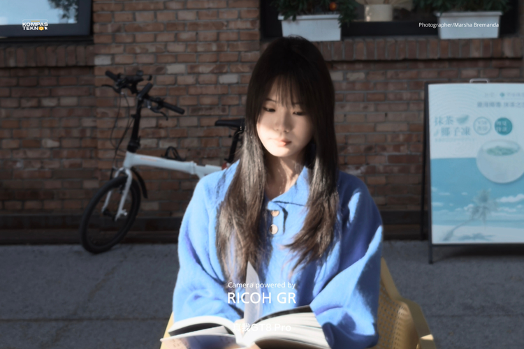 Hasil foto dengan tone Negative Film dari kamera Realme GT 8 Pro x Ricoh menampilkan nuansa warna yang lembut dan sedikit pudar, memberikan kesan klasik pada potret perempuan yang tengah membaca buku.