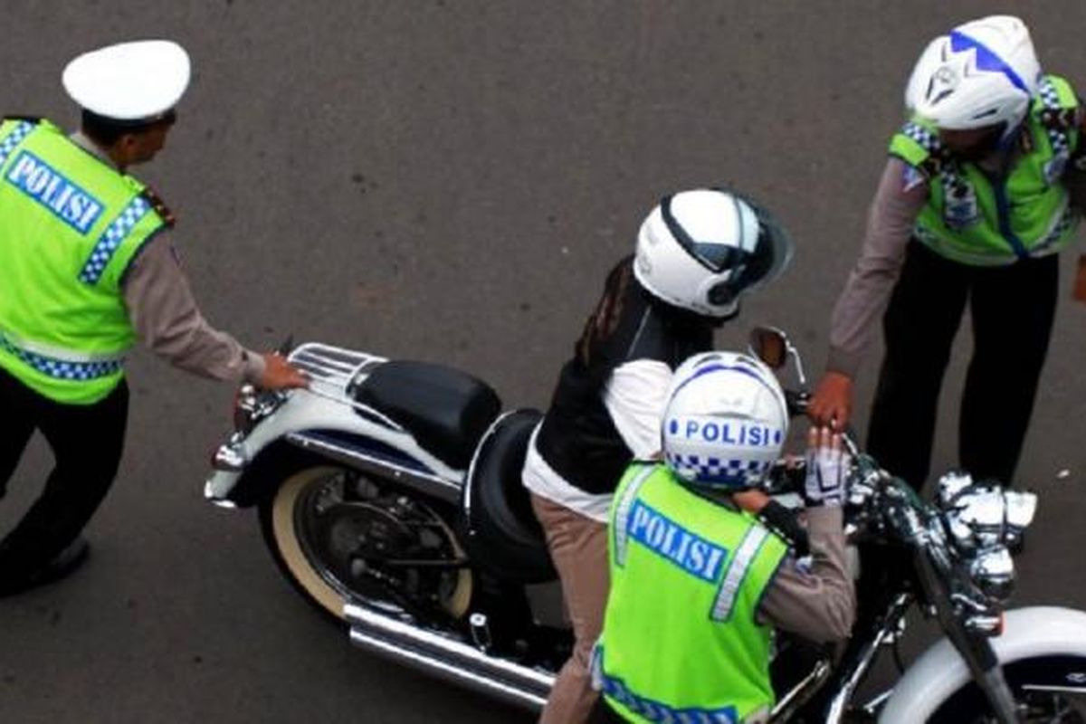 Seorang pengendara Harley Davidson bernomor polisi B 6168 ESG untuk ditilang karena melintasi Jalan MH Thamrin, Jakarta Pusat, yang merupakan kawasan terlarang sepeda motor, Minggu (18/1/2015).