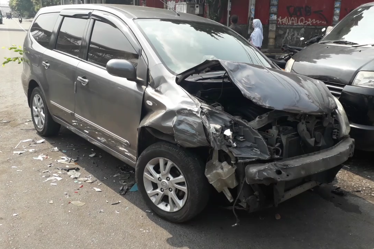 Mobil Grand Livina ringsek akibat terlibat kecelakaan beruntun di Jalan Matraman Raya, Jumat (28/6/2019).
