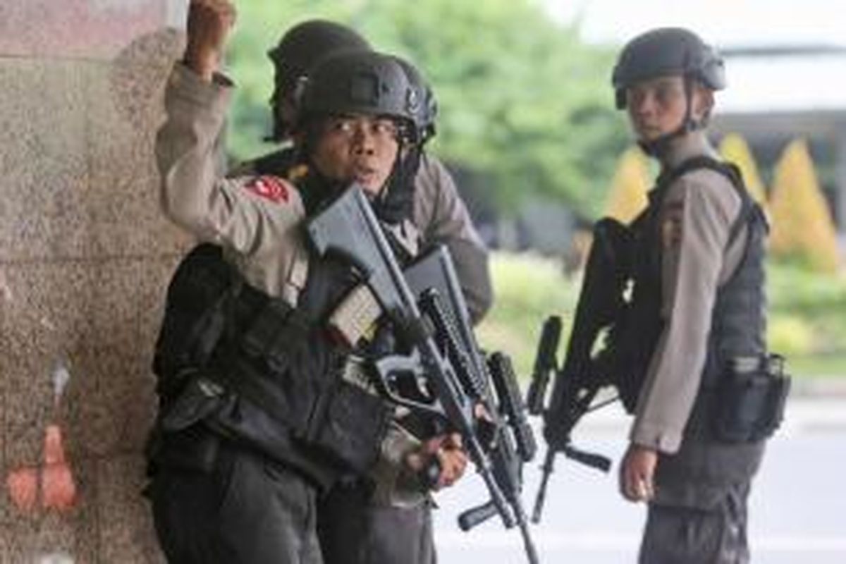 Seorang anggota polisi memberi sinyal dengan tangan kepada rekannya, saat mengejar terduga pelaku ledakan yang menghantam kawasan Jalan MH Thamrin, Jakarta Pusat, 14 Januari 2016. Serangkaian ledakan menewaskan sejumlah orang, terjadi baku tembak antara polisi dan beberapa orang yang diduga pelaku. 