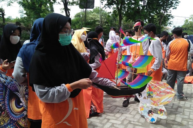 Salah seorang siswi SMA Muhammadiyah 1 Gresik, menunjukkan layang-layang yang dibuat olehnya berbentuk perahu pinisi.