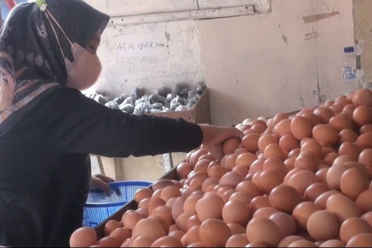 Salah seorang pembeli tengah memilah telur ayam di salah satu agen di Pasar Tradisional Cisalak, Cimanggis, Depok pada Rabu (24/8/2022).