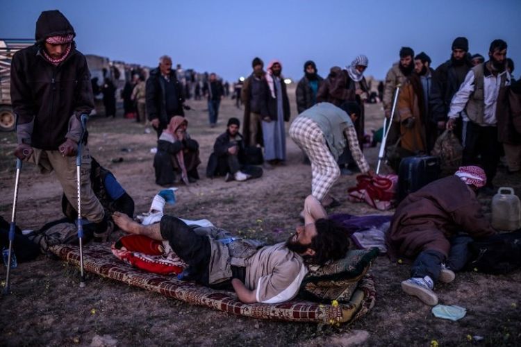 Sekelompok pria yang diduga ISIS ikut dalam rombongan warga yang dievakuasi oleh Pasukan Demokratik Suriah (SDF) dari wilayah terakhir ISIS di Baghouz, Suriah, Senin (4/3/2019). (AFP/BULENT KILIC)