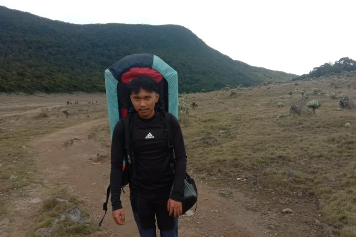 Sosok Daden Nur Zaman (23), porter gunung yang ahli memandu pendakian Gunung Gede Pangrango, Cianjur, Jawa Barat. Pria yang karib disapa Aden ini sudah menjadi porter sejak duduk di bangku SMA atau tepatnya pada tahun 2017 lalu.