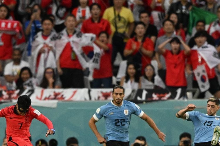 Gelandang Korea Selatan Son Heung-min menembak bola melewati bek Uruguay Martin Caceres dan gelandang Federico Valverde pada laga Grup H Piala Dunia 2022 Qatar antara Uruguay vs Korea Selatan di Education City Stadium di Al-Rayyan, barat Doha pada Kamis 24 November 2022.