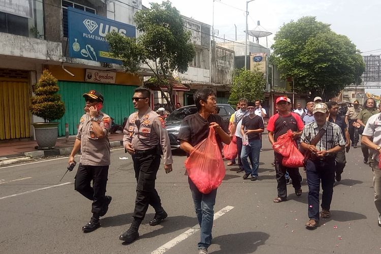 Sejumlah warga Jember saat menebarkan bunga dari pertokoan jompo yang ambruk hingga ke pendopo bupati Jember 