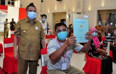 Seorang warga Gorontalo memperlihatkan sertifikat tanah yang baru dimilikinya di samping Wakil Gubernur Idris Rahim.