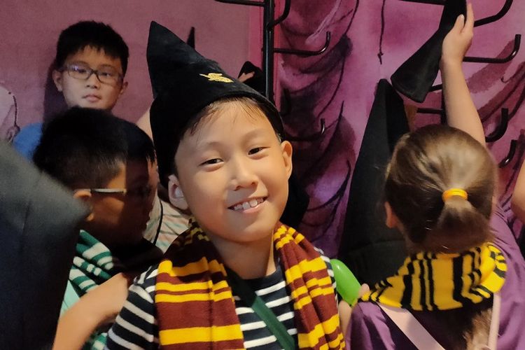Pengunjung anak-anak mencoba memakai topi dan shall penyihir dalam film Harry Potter di Holiday at Mal Taman Anggrek with Harry Potter, Kamis (28/11/2019).