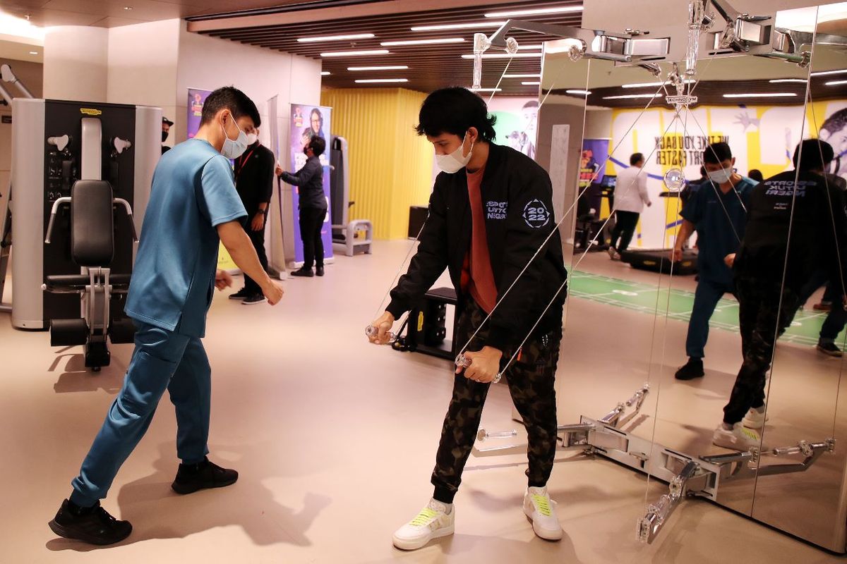 Didampingi oleh terapis dari Sport Medicine, Injury & Recovery Center (SMIRC) RS Pondok Indah Bintaro Jaya, Head Coach EVOS, Muhamad Farchan Ridha (Manay) mencoba alat treatment Kinesis untuk kekuatan otot dalam kegiatan Kinetic Activity Piala Presiden Esports 2022, Selasa (11/10/2022).
