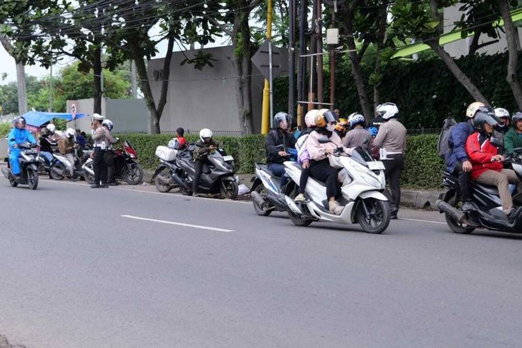 Petugas kepolisian tengah melakukan razia pajak kendaraan di Jalan Raya Kopo-Katapang, Kabupaten Bandung, Jawa Barat, Rabu (10/2/2025)