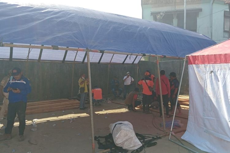 Petugas Badan Penanggulangan Bencana Daerah (BPBD) Kota Ambon membangun tenda darurat untuk para pengungsi korban kebakaran di kawasan Mardika, Ambon, Jumat malam (9/12/2022)