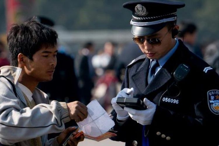 Polisi memeriksa surat-surat yang dibawa seorang pria di Lapangan Tiananmen di Beijing, Kamis (1/11/2012). Penjagaan dan pengamanan ketat diberlakukan menjelang pelaksanaan Kongres Partai Komunis China pada 8 November mendatang. 
