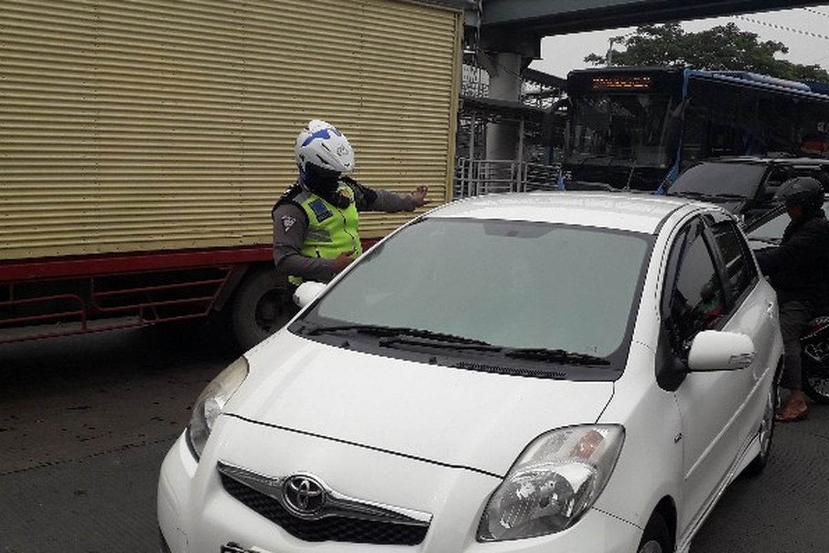 Polisi menilang sebuah kendaraan Mitsubishi Yaris warna putih dalam operasi gabungan di Jalan Daan Mogot KM 13, Jakarta Barat pada Senin (19/11/2018) sekitar pukul 09.45 WIB. 