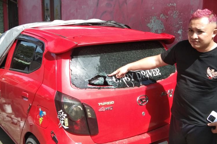 Zakaria menunjukkan jendela mobilnya yang menjadi sasaran tawuran remaja di Kota Magelang, Minggu (14/1/2024).