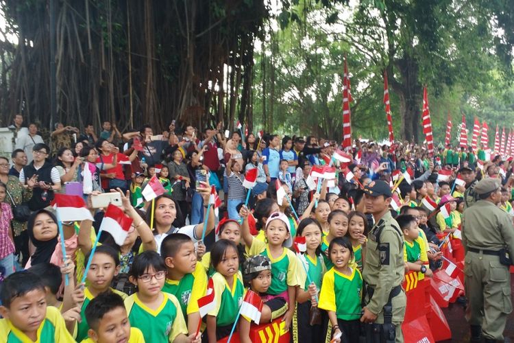 Anak-anak sekolah dan masyarakat Kota Solo menunggu datangnya pawai obor Asian Games 2018 di Jalan Jenderal Sudirman, Solo, Kamis (19/7/2018) siang.