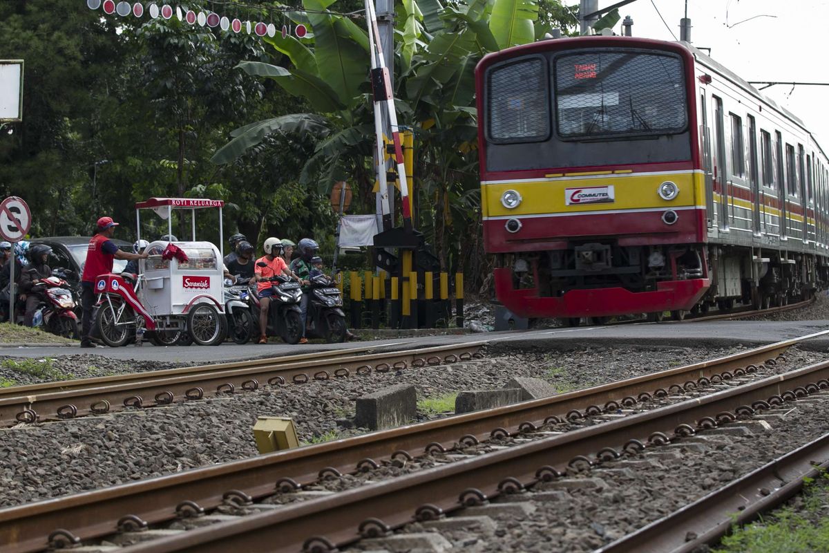 Pengguna jalan melintas di perlintasan kereta api wilayah Bumi Bintaro Permai, Pondok Aren, Jakarta Selatan, Minggu (23/2/2020). Tidak berfungsinya palang pintu di perlintasan kereta api sejak 2 tahun lalu mengancam keselamatan warga.