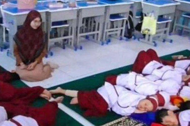 Siswa Sekolah Dasar (SD) Muhammadiyah 4 Zamzam Sidoarjo, Jawa Timur, saat tidur siang didampingi oleh gurunya, Senin (4/12/2023)