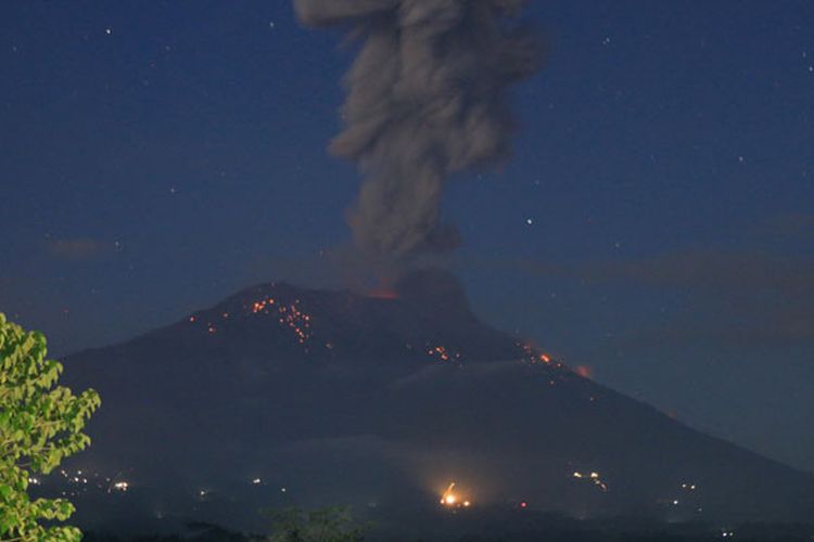 Abu vulkanis dan batu pijar terlontar dari kawah Gunung Agung saat erupsi yang terpantau dari Pos Pengamatan Gunung Api Agung, Karangasem, Bali, Minggu (21/4/2019). Gunung Agung yang berstatus siaga itu kembali erupsi pada pukul 18.56 WITA dengan melontarkan abu vulkanis mencapai ketinggian 3.000 meter dari kawah yang disertai lontaran batu pijar ke lereng gunung tersebut.