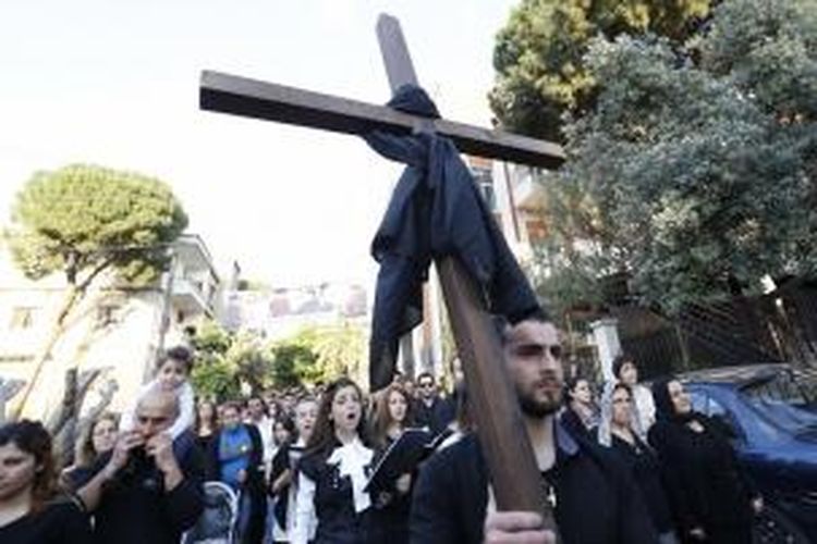 Orang-orang Kristen Assyria, yang melarikan diri kerusuhan di Suriah, membawa sebuah salib di luar Katedral St. Georges di Jdeideh, di Beirut. Orang-orang Assyria yang berbahasa Aramik terusir dari Suriah dan Irak oleh perang dan militan ISIS.