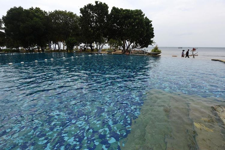 Pengunjung melintas di antara kolam renang dan Pantai Beach Club, Tanjung Lesung, Pandeglang, Banten, Minggu (24/9/2017). Segala keindahan dari Tanjung Lesung membuat pemerintah menetapkan kawasan tersebut menjadi Kawasan Ekonomi Khusus (KEK) Pariwisata di Provinsi Banten.