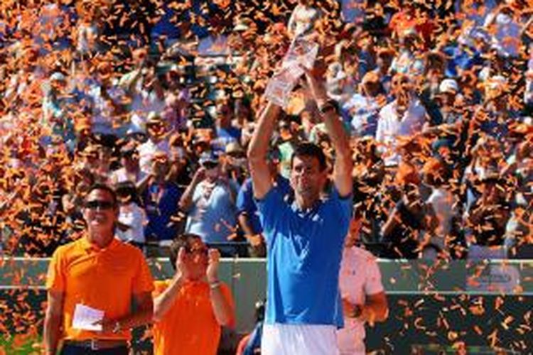 Petenis Serbia, Novak Djokovic, mengangkat trofi juara Miami Terbuka setelah mengalahkan Andy Murray pada laga final di Crandon Park Tennis Center, Minggu (5/4/2015). Djokovic menang 7-6(3), 4-6, 6-0.