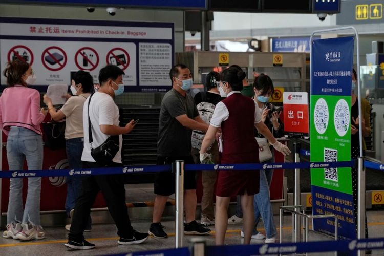 Seorang petugas dari sebuah maskapai meminta para penumpang untuk melaporkan informasi kesehatannya setelah check-in di Bandara Internasional Beijing, Rabu, 24 Agustus 2022.
