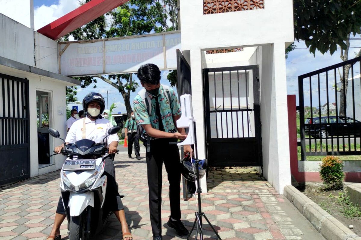 Siswa SMPN 3 Kota Blitar mengecek suhu tubuh di pintu gerbang sekolah, Rabu (5/1/2022)