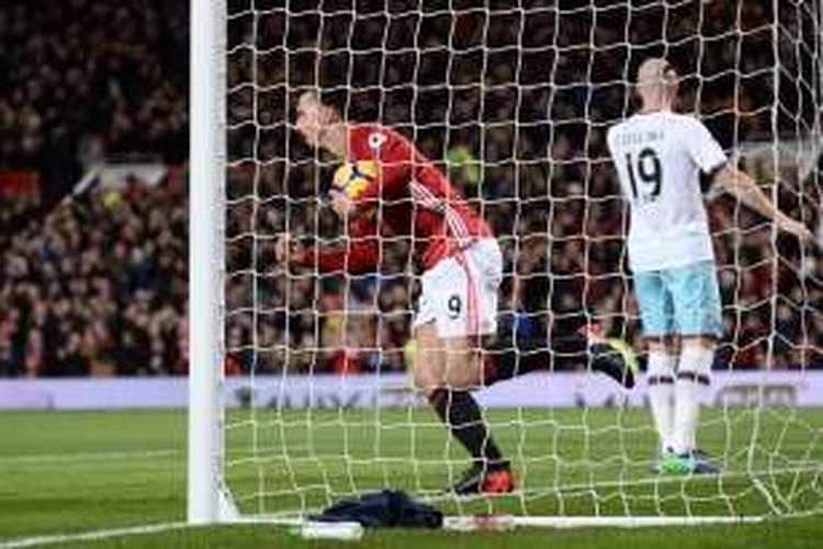 Penyerang Manchester United, Zlatan Ibrahimovic, memungut bola seusai membobol gawang West Ham United pada pertadingan lanjutan Premier League di Old Trafford, Minggu (27/11/2016).  