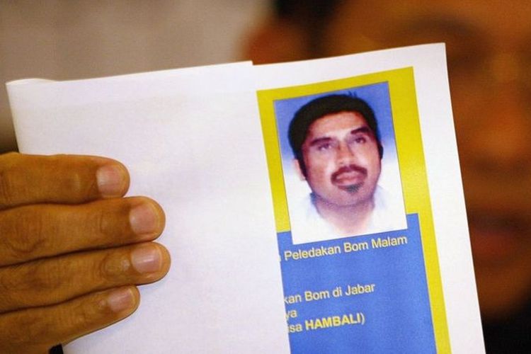 Seorang perwira polisi Indonesia menunjukkan foto Hambali dalam jumpa pers 21 Agustus 2003 di Jakarta, Indonesia.